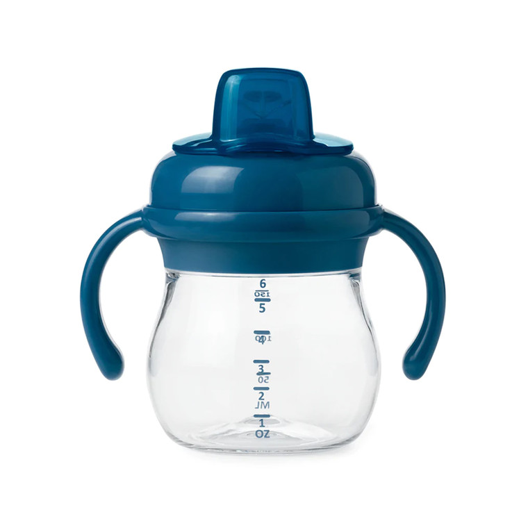 OXO Tot navy blue sippy cup with clear base showing measurement markings and removable side handles on white background