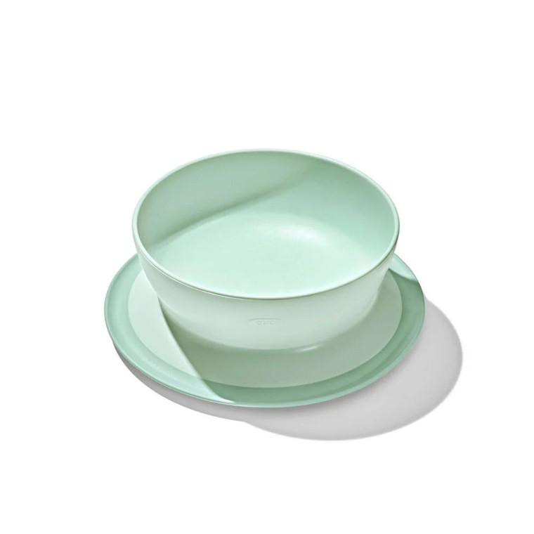 OXO Tot mint green suction bowl with matching plate, showing non-slip base design for baby feeding