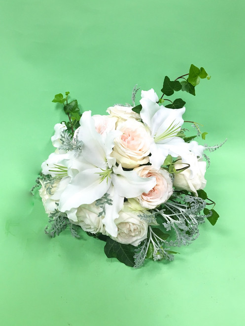Great things come in small packages, with white lilies, blush garden roses and
dusty miller in these smaller bridal bouquet.