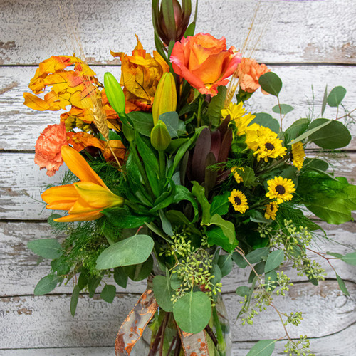 This beautiful arrangement in a clear vase, with fall ribbon and fall colored lilies and roses and a perfect touch to your autumn decorations. This beautiful arrangement in a clear vase, with fall ribbon and fall colored lilies and roses and a perfect touch to your autumn decorations.
