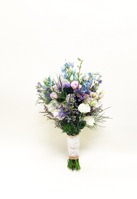Wildflower hand tied bouquet of delphinium, lisianthus and variety of summer filler flowers have that just picked look, tied with burlap and lace. 