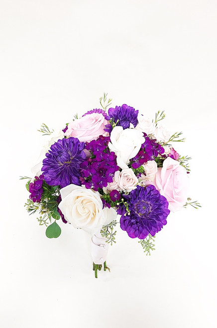 Classic round bouquet in non classic colors.  With beautiful blush roses and bright fuchsia accents of dianthus,  dahlias and asters is a fun summer twist on a classic.