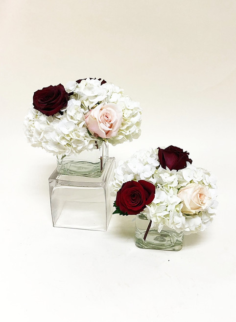 Simple glass cubes of hydrangea, burgundy and blush roses make for an elegant touch for your table centerpieces.