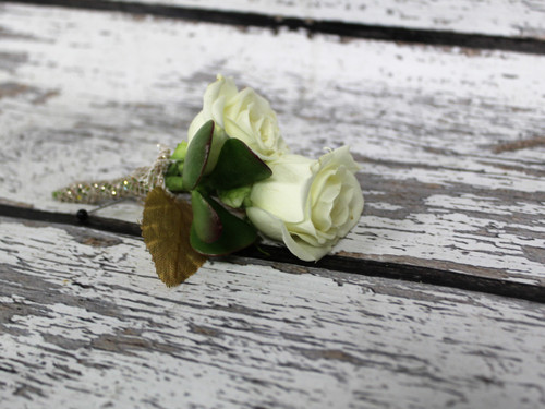 A uniquely designed boutonniere with a succulent, white roses and some bling! Wrapped in gold sparkle ribbon this design is soft but beautiful!
