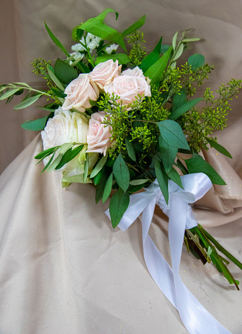 This lovely blend of blush roses with a set of greenery wrapped in a satin ribbon. 