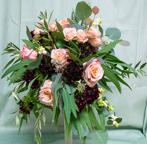 This gorgeous bouquet is designed with pink roses, peonys and set with greenery.