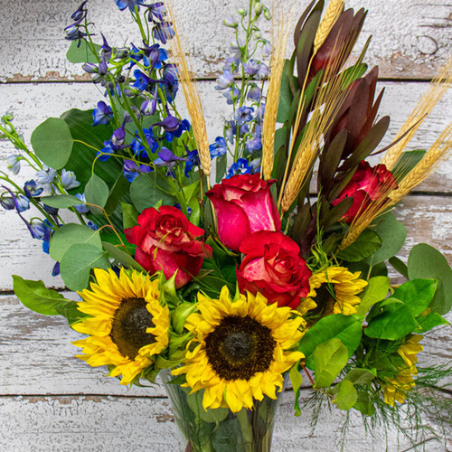 This stunning arrangement in a clear vase will add sunshine to your home with a touch of fall.