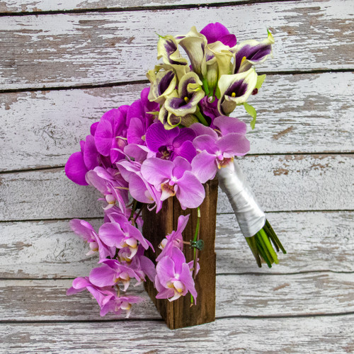 A cascading bouquet of beautiful pink and purple phalaenopsis orchids with white and purple calla lilies.