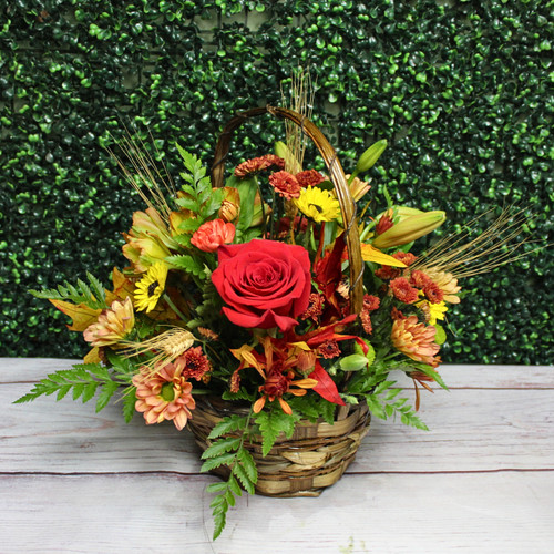 Another example of the Fall Basket arrangement with a red rose, mums, mini sunflowers, and wheat in a woven basket.