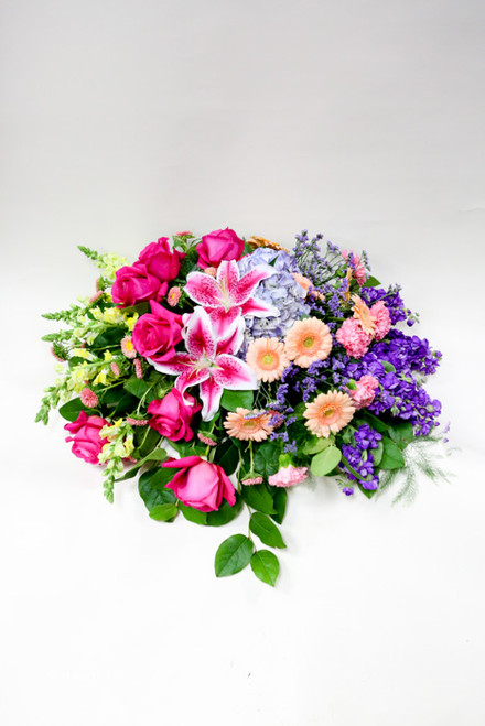 A Vibrant Garden Casket Spray made with Local Grown Lilies and Colored Roses with green fillers and other mixed fresh flowers, brought to you by the Girls at Earle's. 