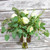 Different types of eucalyptus with a hint of white roses arranged in a hand-tied bridal bouquet.