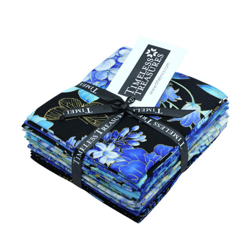 Timeless Treasures Fabrics Escapade 12 Fat Quarters 18 By 22, neatly folded with a black ribbon and a label, showcasing vibrant blue floral patterns on various fabric pieces. Timeless Treasures Fabrics Escapade 12 Fat Quarters 18 By 22, neatly folded with a black ribbon and a label, showcasing vibrant blue floral patterns on various fabric pieces.