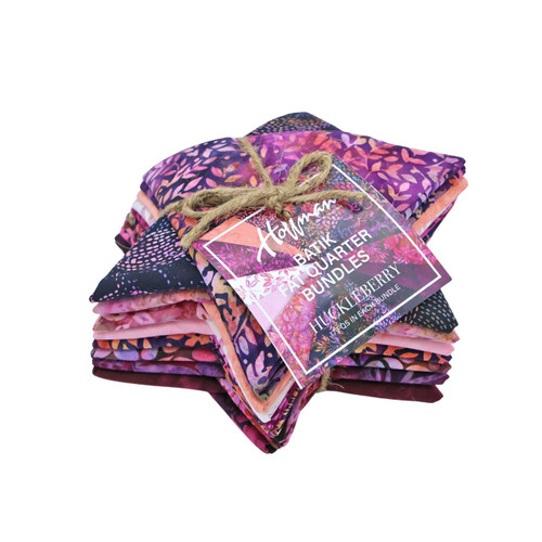 Hoffman Fabrics Bali Batik Hand Dyed Batik 17 Fat Quarters Purple Pink, colorfully arranged fabric bundle with floral and abstract patterns, tied with a rustic twine bow.