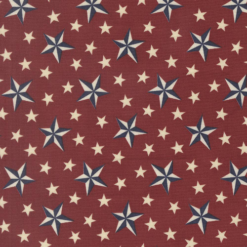 Moda Fabrics America 250 Years Deb Strain Tossed Stars Americana Red, printed fabric with white and navy blue stars on a red background, perfect for patriotic-themed sewing projects.
