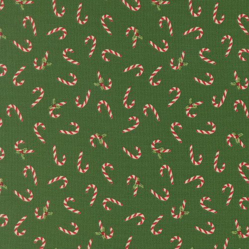 Moda Fabrics Holiday Cheer Stacy Iest Hsu Candy Canes Evergreen Green, festive fabric with red and white candy canes and small green holly leaves on a green background.