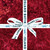 Lumin Fabrics Island Batik Everbloom Batiks 5 Inch Squares, red fabric with intricate floral and abstract patterns and a white ribbon tied in a bow with 'Island Batik' and a gecko logo printed on it.