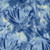 Lumin Fabrics Island Batik Meadow Brook Batiks Queen Anne's Lace Powder Blue, floral batik fabric with white flower designs on a blue and yellow watercolor background.