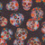 Quilting Treasures Fabrics Skullduggery Black Sugar Skulls, vibrant sugar skulls with colorful floral and swirl patterns on a black background.