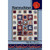 Villa Rosa Designs Maraschino Quilt Pattern, an intricate quilt with red, blue, white, and floral fabric pieces arranged in a detailed patchwork design.