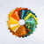 Riley Blake Fabrics Expressions Batiks Starburst Groove 10 Inch Stacker, 42 Pcs, colorful fabric squares arranged in a circular pattern on a white background.
