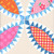 Windham Fabrics Made Easy Denyse Schmidt Cheater Quilt Pearl Cream Tobacco Leaf, close-up of colorful quilt blocks with floral, geometric, and plaid patterns in pink, red, blue, and cream shades.