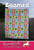 Villa Rosa Designs Loomed Pattern quilt with colorful floral and geometric designs, vibrant pink, green, blue, and yellow colors, displayed outdoors.