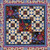 Quilting Treasures Midnight Petals Star Grid Digital Quilt Top, a colorful quilt featuring floral patterns, star motifs, and a vibrant border design.