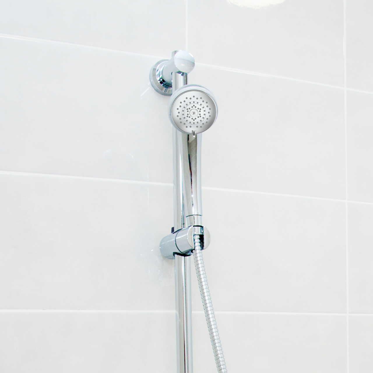 HealthGuard handheld chrome showerhead on showerwall