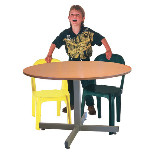 Round Supawood (MDF) Baby Table, image showing a child standing behind a round wooden table with two plastic chairs, one yellow and one green. Round Supawood (MDF) Baby Table, image showing a child standing behind a round wooden table with two plastic chairs, one yellow and one green.