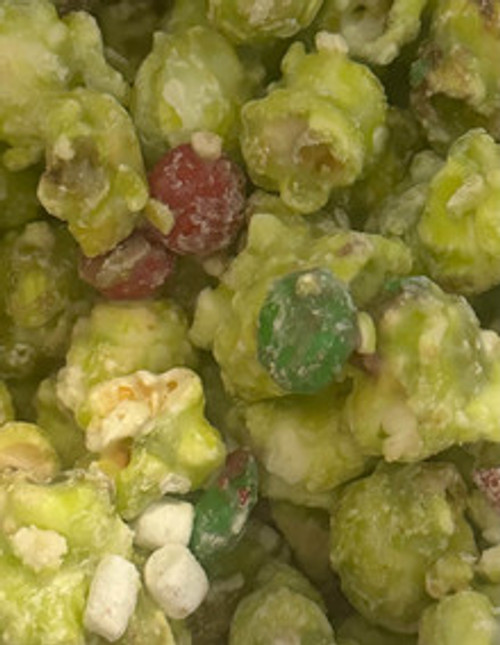 Grinchmas popcorn with cookie butter, M&Ms, and white chocolate drizzle for festive snacking.