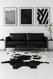 Black &  white  Spotty  Cowhide on white  tiled  floor in front  of modern black lounge  suite