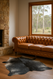 Grey spotted cowhide rug with soft contrast and natural pattern shown with  Chesterfield  Sofa