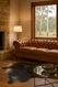 Grey  Spotted  Brazilian  Cowhide  shown  in  room  setting  in  front  of  chesterfiled  lounge with  lamo  in  corner  and  woodland  scene  out  of  large  window