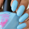 Crystal Blue Persuasion Nail Polish, bottle of sky-blue nail polish with freshly painted nails showing the color application.