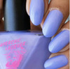 Synchronicity Nail Polish, light purple painted nails with a glossy finish next to the nail polish bottle.
