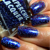 In The Twinkling Of An Eye Nail Polish, close-up of fingers with glittery, holographic blue and purple nail polish.