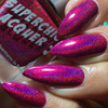 Trap Queen Nail Polish, vibrant holographic pink and purple glitter nail polish on manicured nails.