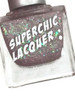 Love Stinks Nail Polish, glittery purple nail polish with a holographic shimmer in a clear glass bottle.