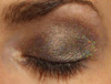 Coco Holographic Eyeshadow, close-up of a closed eye with shimmering, holographic makeup on eyelids.