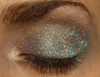Cotton Candy Creature Holographic Eyeshadow, close-up of a person's closed eye showcasing multi-colored, sparkling holographic eyeshadow with glitter effect on eyelid.
