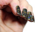 Bittersweet Oil Spill Nail Polish, close-up of black nail polish with multicolored holographic glitter on fingernails.