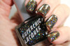 Bittersweet Oil Spill Nail Polish, close-up of a hand showing nails painted with glittery, multicolored nail polish in a black bottle.