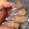 Holly Lolly Nail Polish, hand showcasing multi-colored glitter nail polish on fingernails with a sparkly background.