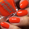 Amused Thermal Nail Polish, vibrant orange nail polish on neatly manicured fingernails with water droplets for a fresh look.