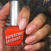 Amused Thermal Nail Polish, pedestrian with manicured nails holding a bottle of bright orange nail polish against a glittery background.