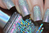 Happy Thoughts Nail Polish, close-up of nails painted with holographic glitter nail polish exhibiting rainbow shimmer and sparkles.