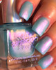 Unreal Nail Polish, iridescent light blue and pink holographic nail polish on manicured nails.