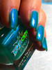 World Warp Nail Polish, vibrant blue-green nail polish applied on manicured nails.