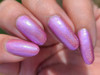 Samantha Nail Polish, close-up of manicured nails painted with shimmering, iridescent purple nail polish.