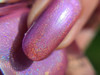Samantha Nail Polish, close-up of a fingernail painted with glittery purple nail polish.